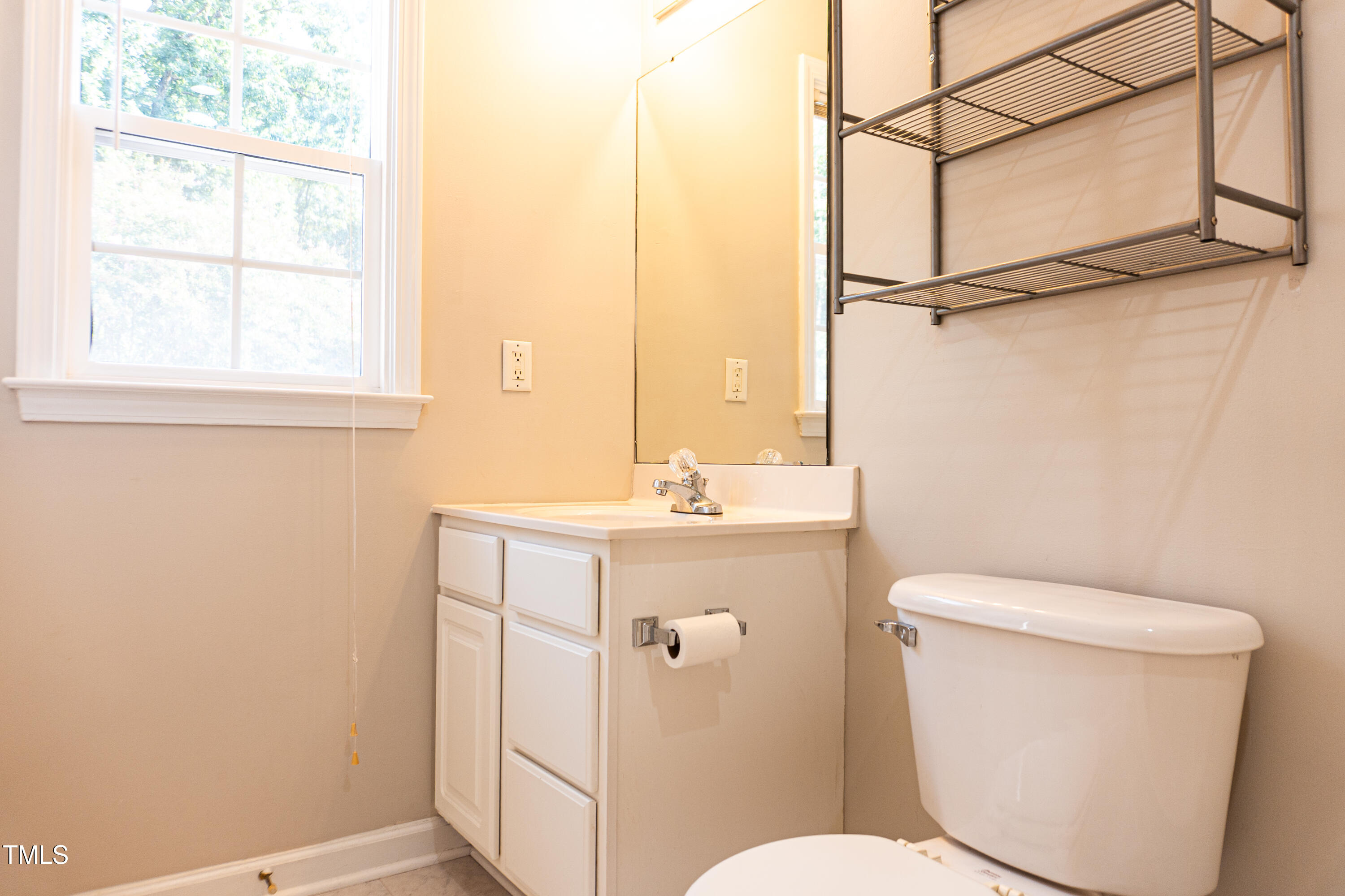 2271 Trailwood Valley Circle Raleigh, NC 27603 - Photo 27 of 36 a bathroom with a toilet a sink and a window