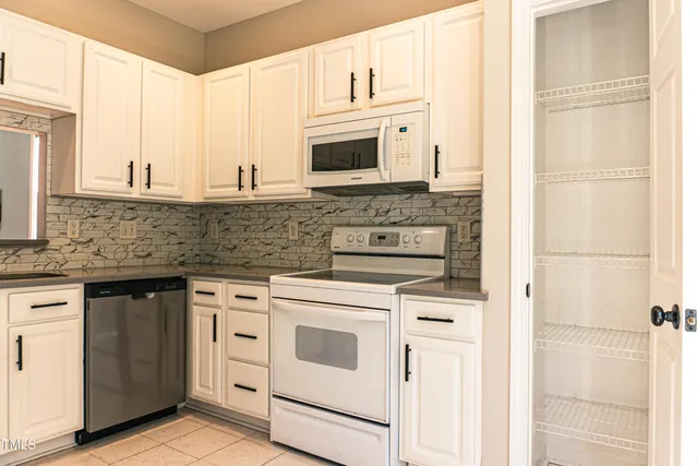 a kitchen with white cabinets and white appliances