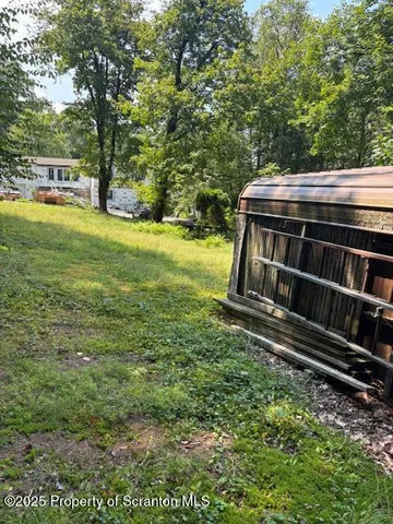 a view of a yard with wooden fence