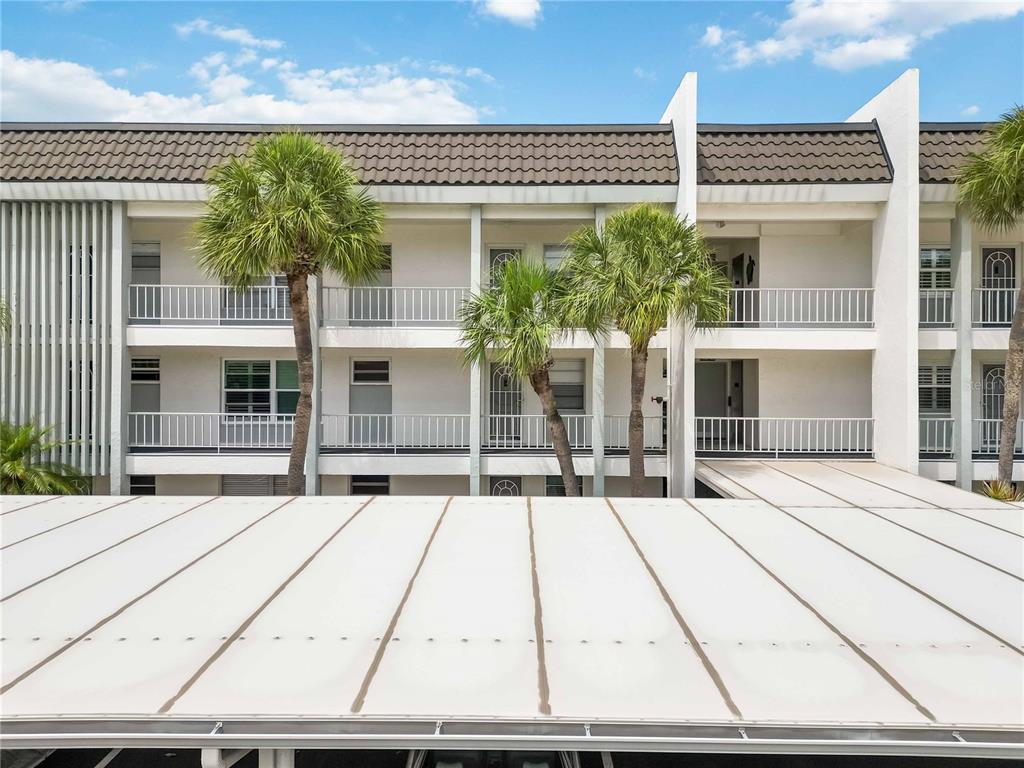 4420 Exeter Drive, Unit 204 Longboat Key, FL 34228 - Photo 1 of 1 a view of a white house with a large window and potted plants