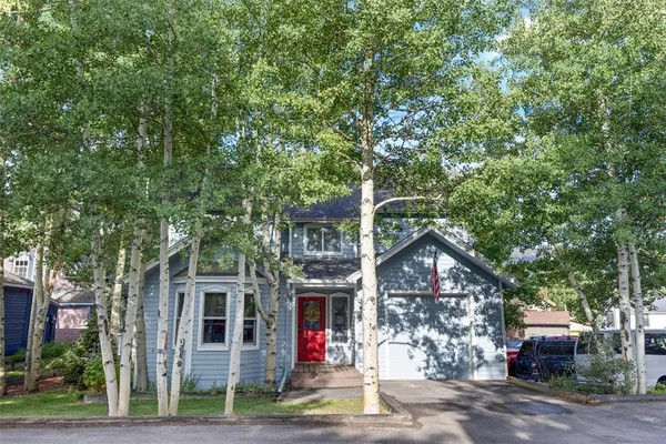 a front view of a house with a tree