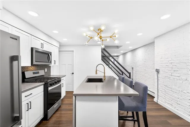 a kitchen with a stove cabinets and wooden floor