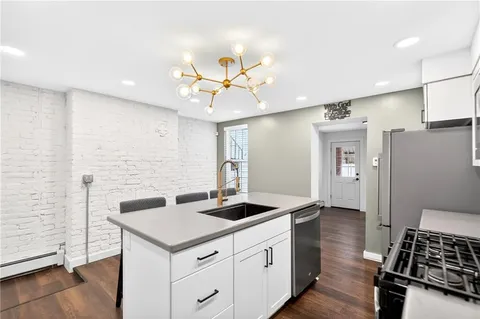 a kitchen with stainless steel appliances a stove microwave and sink