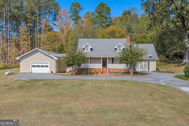 a front view of house with yard and trees in the background