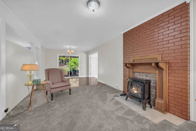 a living room with furniture a fireplace and a large window
