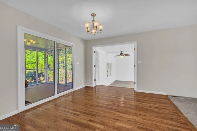 a view of a livingroom with wooden floor and a chandelier