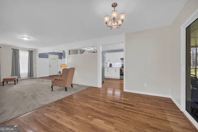 a view of a big room with windows and chandelier fan