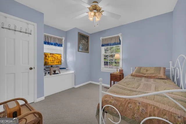 a bedroom with a bed and a lamp on the dresser