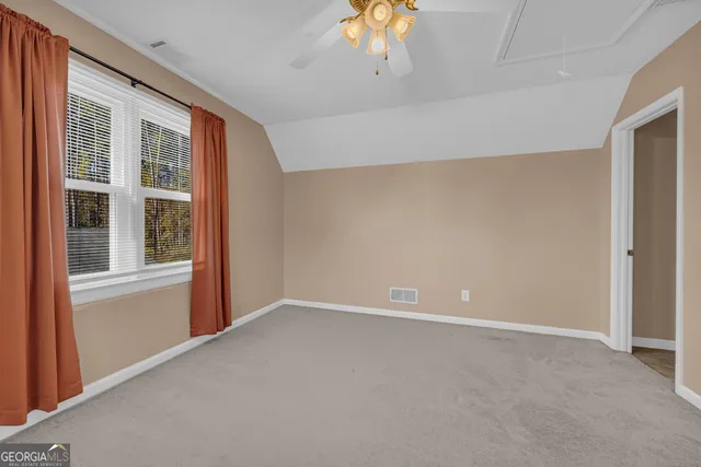 an empty room with a chandelier fan and closet