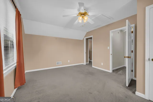 a view of an empty room with a chandelier fan