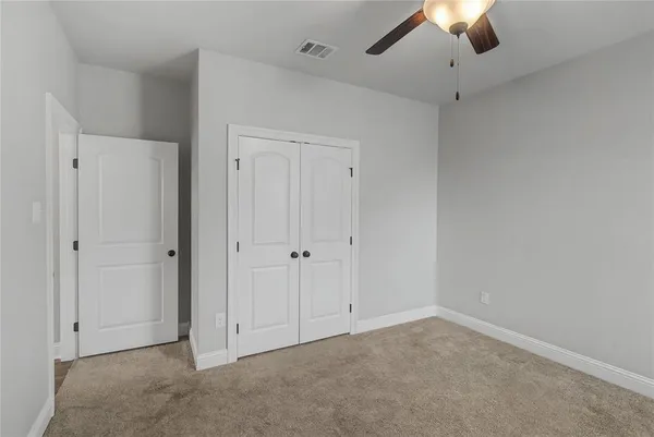 an empty room with a ceiling fan and a window