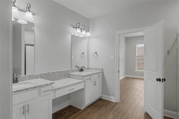 a spacious bathroom with a granite countertop sink a mirror and shower