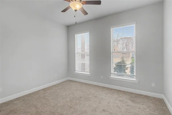 an empty room with a window and a ceiling fan