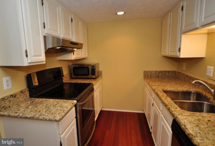 10902 Harpers Square Court Reston, VA 20191 - Photo 2 of 19 a kitchen with stainless steel appliances granite countertop a sink a stove and a microwave