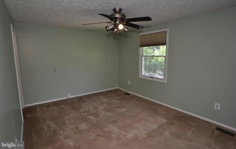10902 Harpers Square Court Reston, VA 20191 - Photo 16 of 19 an empty room with a window and a chandelier fan
