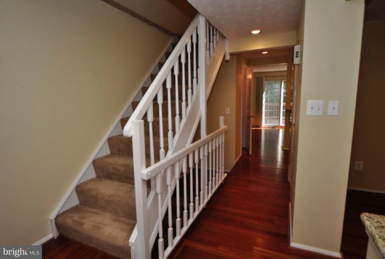 10902 Harpers Square Court Reston, VA 20191 - Photo 3 of 19 a view of staircase with wooden floor and white walls