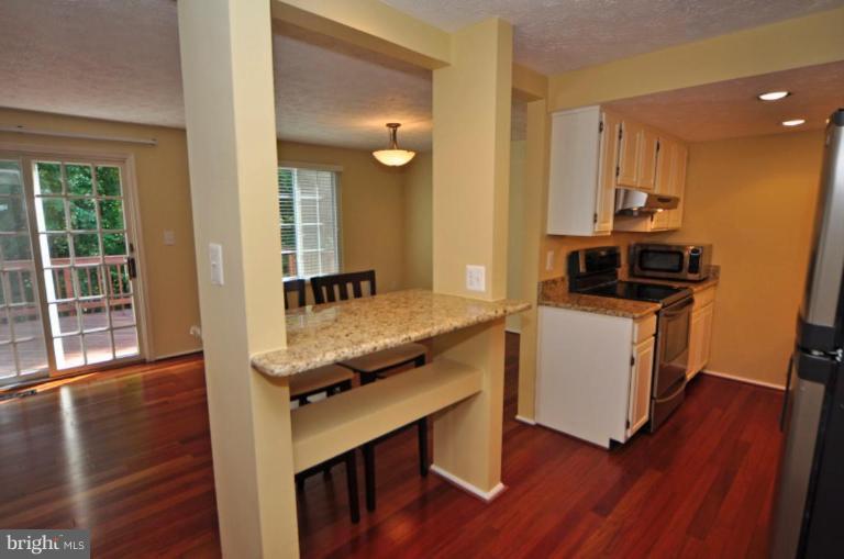 10902 Harpers Square Court Reston, VA 20191 - Photo 6 of 19 a room with kitchen island a wooden floor and a sink