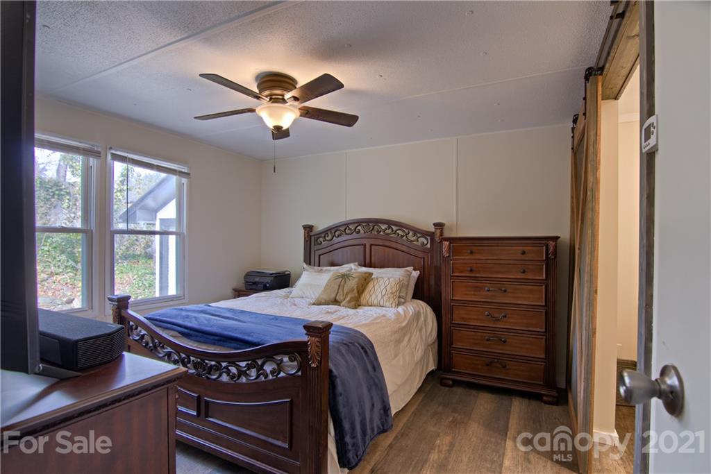73 Church Road Fairview, NC 28730 - Photo 14 of 45 a bedroom with a bed and a dresser next to a window