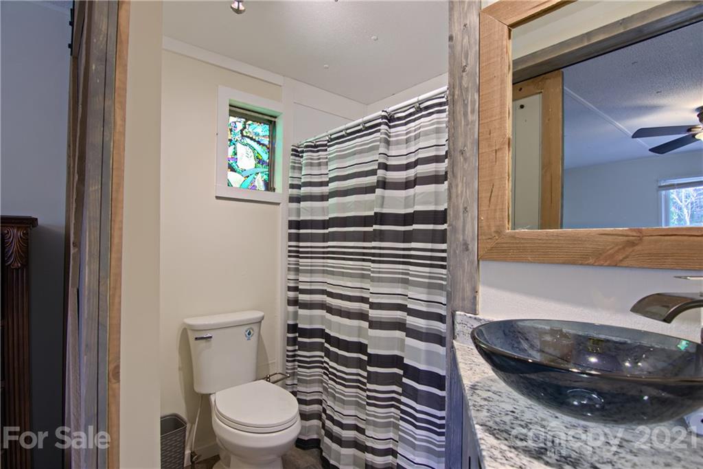 73 Church Road Fairview, NC 28730 - Photo 17 of 45 a bathroom with a granite countertop toilet and a sink