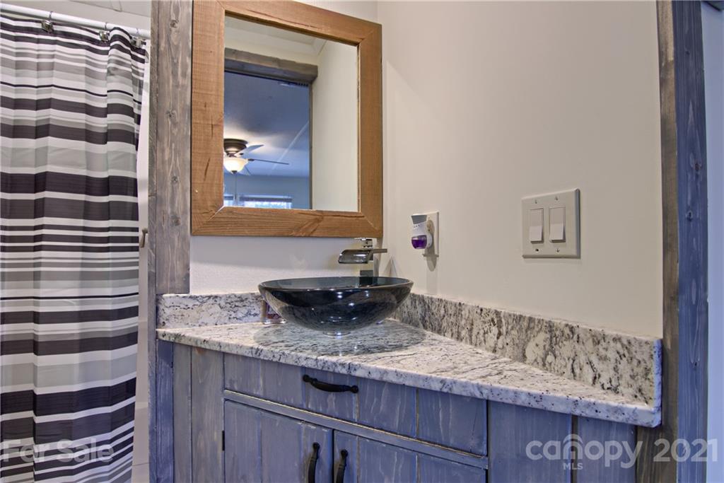 73 Church Road Fairview, NC 28730 - Photo 18 of 45 a bathroom with a granite countertop sink and a mirror