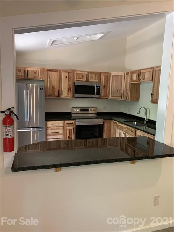 73 Church Road Fairview, NC 28730 - Photo 38 of 45 a kitchen with stainless steel appliances granite countertop a stove a sink and a refrigerator