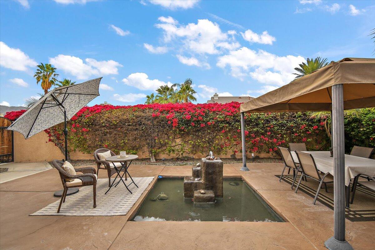 45510 Desert Fox Drive La Quinta, CA 92253 - Photo 9 of 49 a view of a patio with dining table and chairs with wooden fence