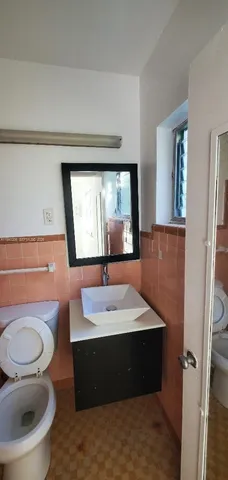 a bathroom with a sink a toilet and a mirror