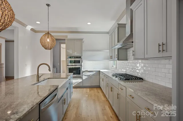 an empty room with windows and chandelier fan
