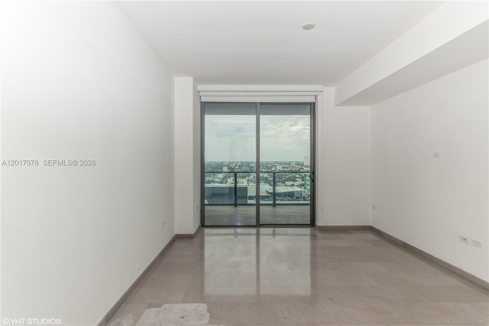 88 Southwest 7th Street, Unit 2508 Miami, FL 33130 - Photo 9 of 18 an empty room with wooden floor and windows