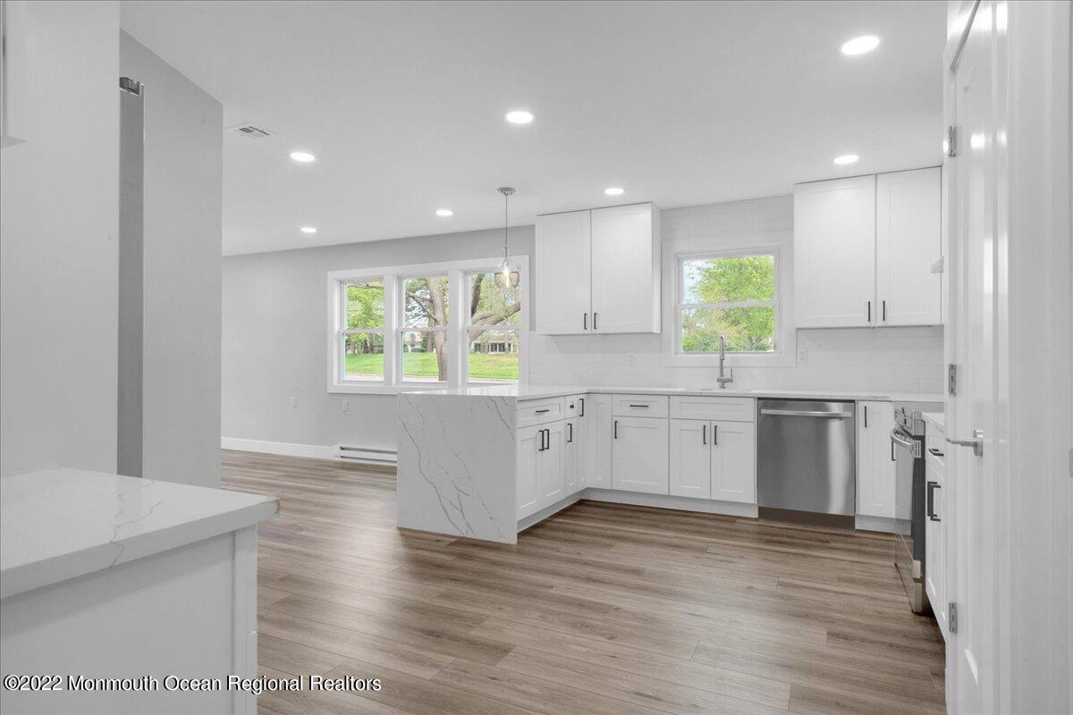 2 Bryant Road Brick, NJ 08724 - Photo 9 of 28 a kitchen with stainless steel appliances granite countertop a stove a sink and white cabinets with wooden floor