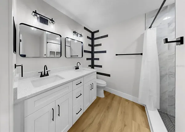 a bathroom with a sink a toilet and shower