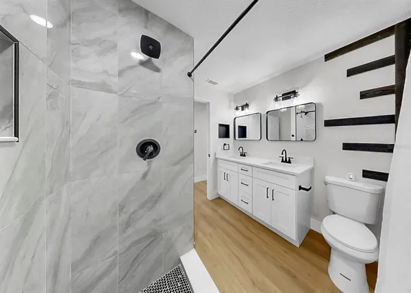a bathroom with a sink a large mirror and shower