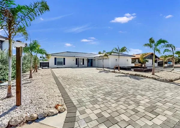 a view of a house with backyard and sitting area