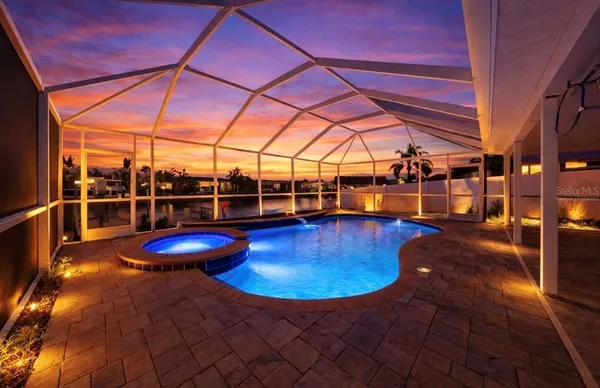 a view of a swimming pool with a patio and a yard