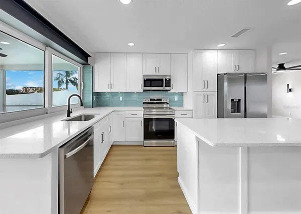 a kitchen with white cabinets and white appliances