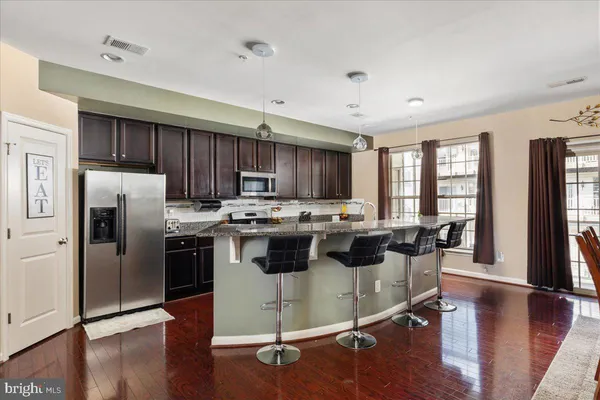 a kitchen with a stove a refrigerator and wooden floor