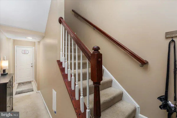 a view of staircase with lots of frames on wall and wooden floor