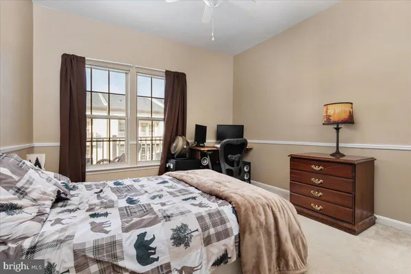 a spacious bedroom with a bed a dresser and a book shelf