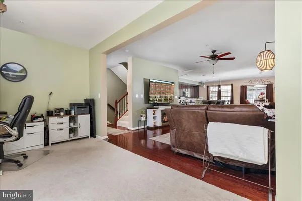 a living room with furniture kitchen view and a window