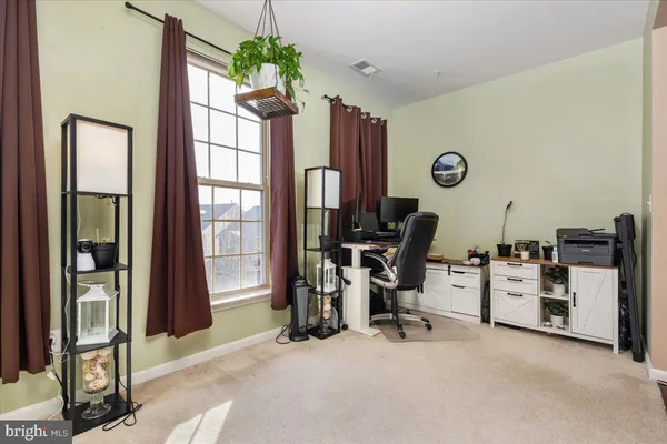 a view of a workspace with furniture and a window