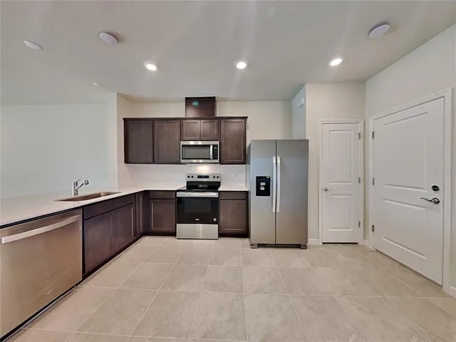 a large kitchen with a refrigerator and a sink