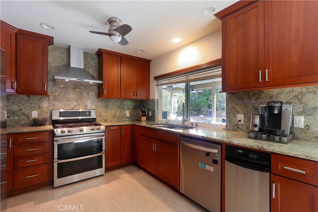 8 Sandpiper Irvine, CA 92604 - Photo 20 of 45 a kitchen with stainless steel appliances granite countertop wooden cabinets stove top oven and sink