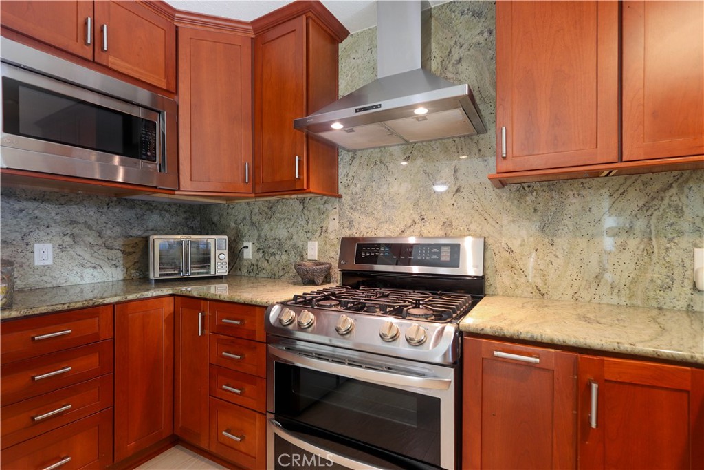 8 Sandpiper Irvine, CA 92604 - Photo 21 of 45 a kitchen with stainless steel appliances granite countertop a stove microwave and sink