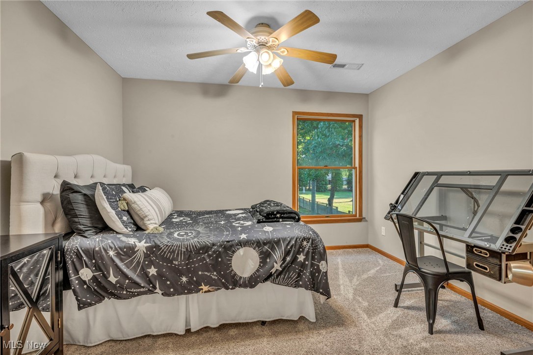 14902 Kneisel Road Vermilion, OH 44089 - Photo 27 of 49 Bedroom featuring ceiling fan, a textured ceiling, and carpet