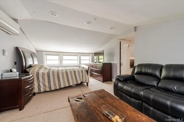 a bedroom with a bed couch and a window