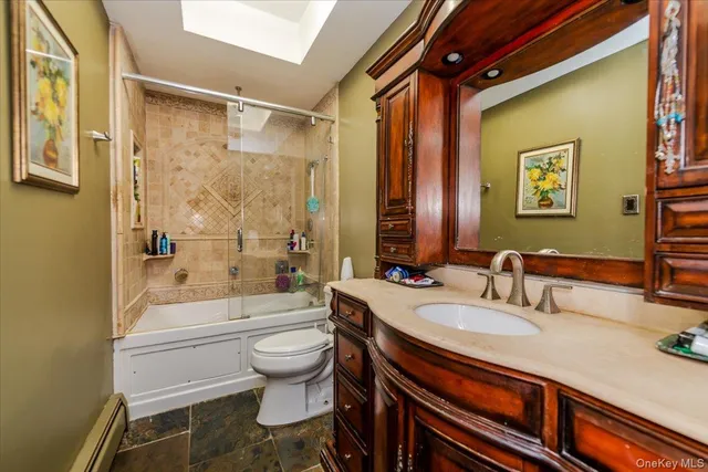 a bathroom with a sink a toilet a mirror a vanity and bathtub