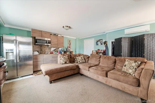 a living room with furniture and a open kitchen view
