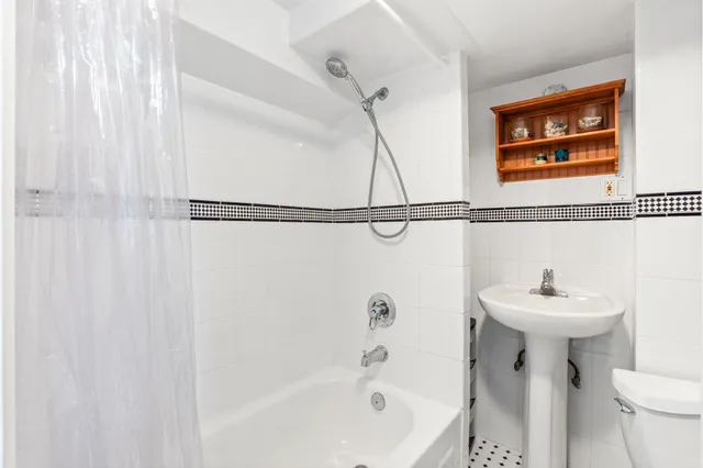 a bathroom with a sink a mirror toilet and bathtub