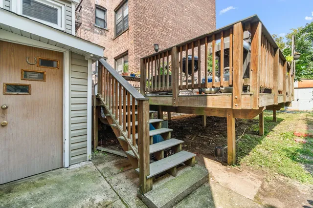a view of wooden balcony with two chairs and a fence