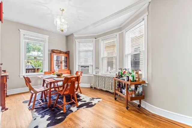 a dining room with furniture a chandelier and wooden floor